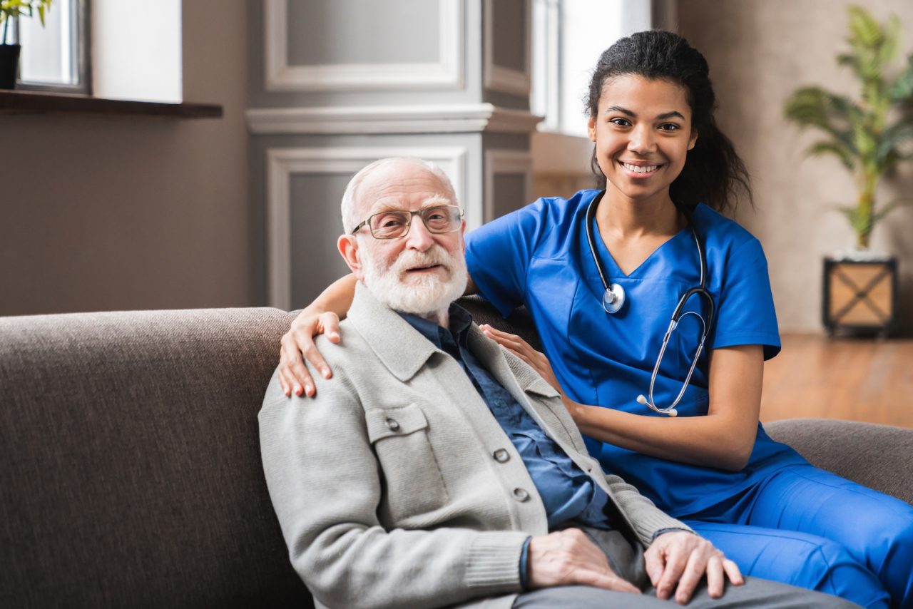 front-view-portrait-of-caring-afro-nurse-taking-care-of-an-elderly-caucasian-man-grandfather